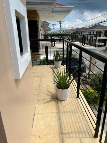 a balcony with two potted plants on a building at Casa Almera in Totolan