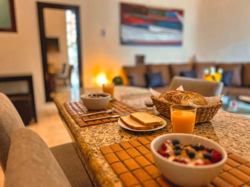 a breakfast table with bread and a bowl of food at Maya Villa Condo Hotel and Beachclub in Playa del Carmen