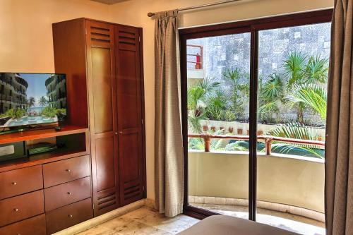 a bedroom with a sliding glass door to a balcony at Maya Villa Condo Hotel and Beachclub in Playa del Carmen
