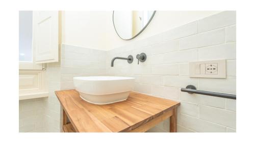 a bathroom with a white sink on a wooden table at Green Guest House Alghero in Alghero