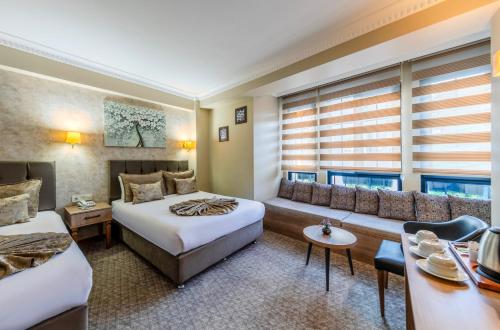 a hotel room with two beds and a couch at Sultan Hamit Hotel in Istanbul