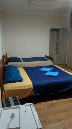 a bedroom with two beds with blue sheets and a table at New Wave1 in Grigoleti