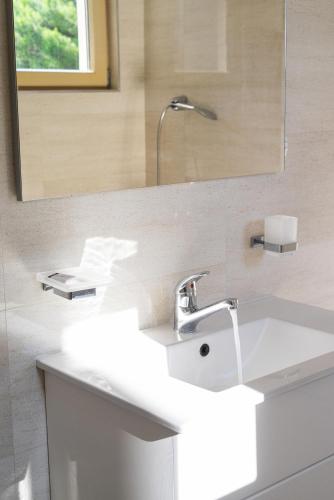 a bathroom with a white sink and a mirror at Vertmont Villa in Sveti Stefan