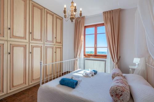 Un dormitorio con una cuna con almohadas azules y una ventana. en Le Lanterne - Villa vista mare, en Massarosa