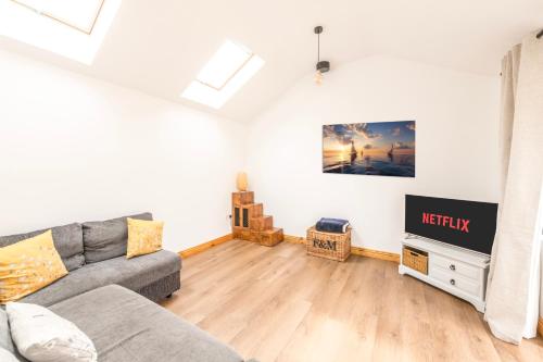 a living room with a couch and a tv at Well-located countryside cottage in Nailsea