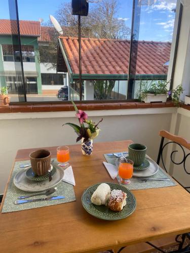 une table avec deux assiettes de nourriture et de jus d'orange dans l'établissement Pousada Corumbatahy, à Corumbataí