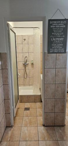 ein Badezimmer mit Dusche und Badewanne mit Schild in der Unterkunft Ascunzis in Bicaz