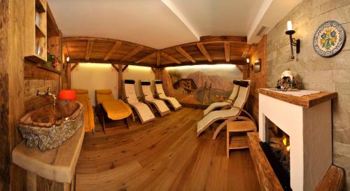 a room with a couch and chairs in a train room at Hotel Garni Concordia - Dolomites Home in Selva di Val Gardena