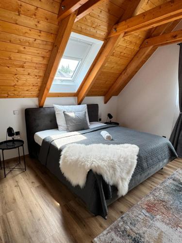 a bedroom with a large bed with a window at bystřice park Chata Voda in Včelákov