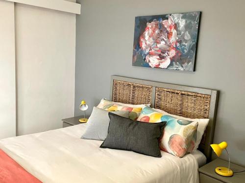 a bedroom with a bed and a painting on the wall at Lekkerus144 in Kleinmond