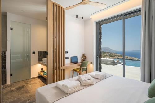 a bedroom with a bed and a view of the ocean at Astelia Residence in Kókkinon Khoríon