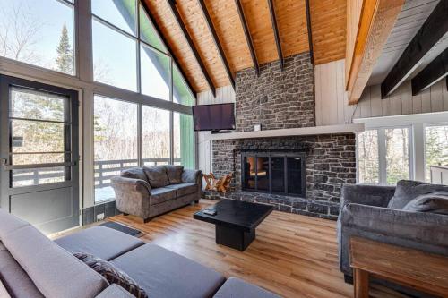a living room with a stone fireplace in a house at Mountain View 148 - 4 chambres - 13 personnes in Beaupré