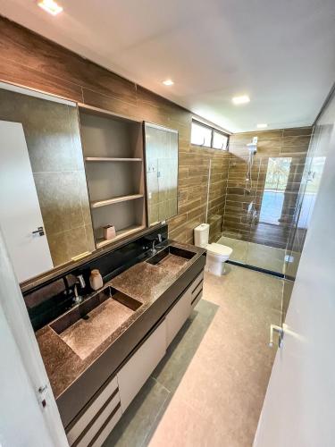 a bathroom with a double sink and a toilet at Casa com 4 suítes, piscina, a 20m do mar| Milagres in Barra do Camaragibe