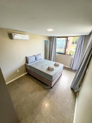 a bedroom with a bed and a large window at Casa com 4 suítes, piscina, a 20m do mar| Milagres in Barra do Camaragibe