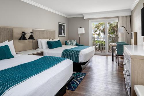 a hotel room with two beds and a balcony at Delray Sands Resort in Boca Raton