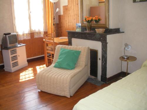 - un salon avec une chaise et une cheminée dans l'établissement Gîtes autonomes chez l'habitant 2, à Bagnères-de-Bigorre