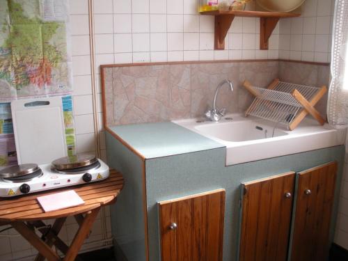 une cuisine avec un évier et une cuisinière dans l'établissement Gîtes autonomes chez l'habitant 2, à Bagnères-de-Bigorre