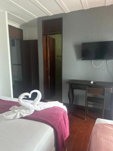 a hotel room with two beds with a heart shaped towel at Dom Aquino Hotel e Gastronomia in Natal