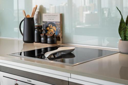 a kitchen counter with a stove with a spoon on it at Modern Suite Calgary Downtown 5 min walk Stampede in Calgary