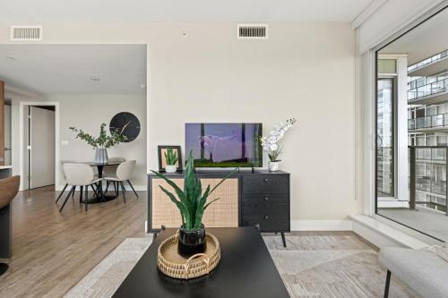 a living room with a tv and a table at Modern Suite Calgary Downtown 5 min walk Stampede in Calgary