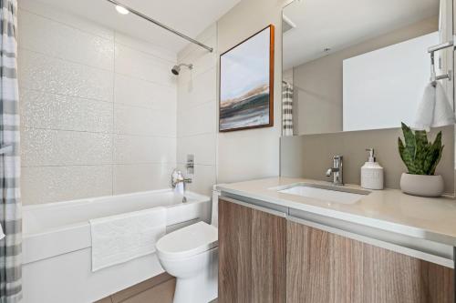 a bathroom with a sink and a toilet and a tub at Modern Suite Calgary Downtown 5 min walk Stampede in Calgary