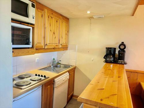 une cuisine avec un évier et une cuisinière four supérieur dans l'établissement Résidence Valeriane - La Valériane 18 - Appartement offrant une vue magnifique sur la vallée MAE-5364, à Valmorel