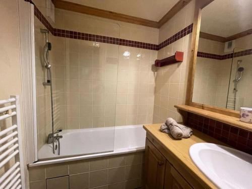 une salle de bain avec une baignoire, un lavabo et un miroir dans l'établissement Résidence Valeriane - La Valériane 18 - Appartement offrant une vue magnifique sur la vallée MAE-5364, à Valmorel