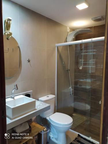 a bathroom with a toilet and a sink and a shower at Casa do Lago Fiore in Paripueira