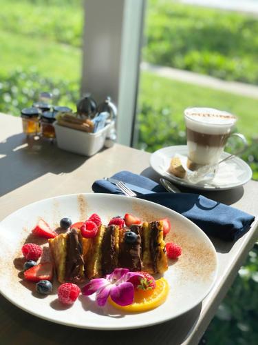 a plate of food with fruit and a cup of coffee at Delray Sands Resort in Boca Raton