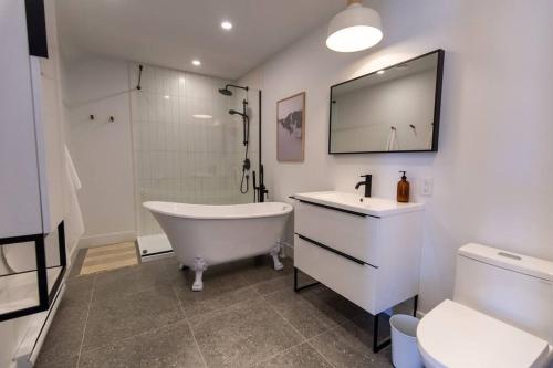 un bagno con vasca, lavandino e specchio di Luna - 5 chambres - 14 personnes a Saint-Férréol-les-Neiges