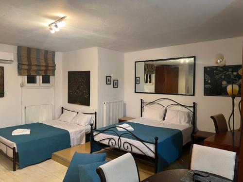 een slaapkamer met twee bedden en een tafel en stoelen bij 50m from beach in PalaiónTsiflíkion