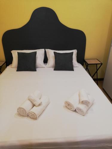a white bed with three towels on it at Candelieri Suites in Sassari