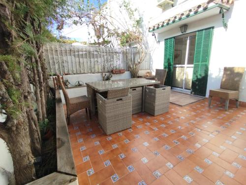 a patio with a table and chairs on a brick floor at Casa Adosada Mirador de Sevilla in Tomares