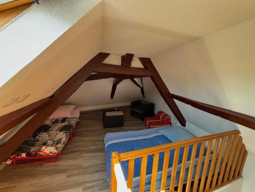Cette chambre mansardée comprend un lit et un escalier. dans l'établissement Chic et relax version chambre en mezzanine de 7 places, à Montmarault