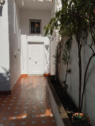 a hallway with a white door and a tree at Casa Adosada Mirador de Sevilla in Tomares