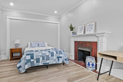 Un dormitorio con una cama y una chimenea. en Beautiful Green Door Brownstone, en Jersey City