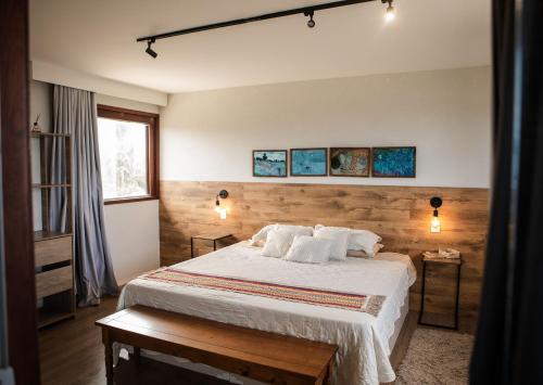 a bedroom with a bed with white sheets and pillows at Casa com 5 suítes, sauna, piscina e área gourmet in Francês