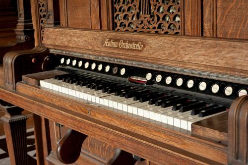 an old piano is sitting in a room at Springkell in Eaglesfield