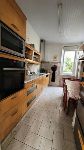 une cuisine avec des armoires en bois, une table et une fenêtre dans l'établissement Résidence 590-pleneuf Val Andre - Vacances les pieds dans l'eau, dans le coeur de la station du VAL ANDRE MAE-5191, à Pléneuf-Val-André