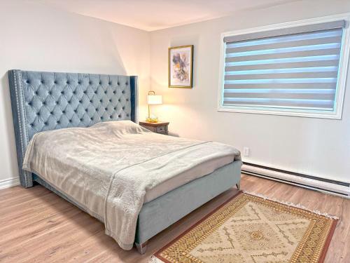 a bedroom with a blue bed and a window at Charming Cottage on Lake Simcoe in Orillia