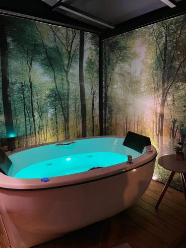 a bath tub in a room with a forest mural at Pousada Sitio Raizes in Siderópolis