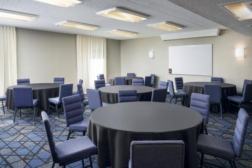 a conference room with tables and chairs and a whiteboard at Courtyard by Marriott Little Rock West in Little Rock
