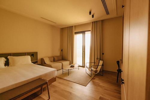 a bedroom with a bed and a couch and a window at Aethos Saragano in Saragano