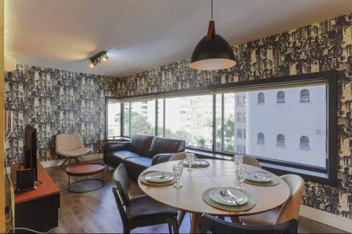 un salon avec une table et un canapé dans l'établissement Vn Al Campinas Refugio Moderno, à São Paulo