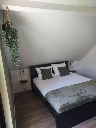 a bedroom with a bed with a plant on the wall at Heerlijk Huys, Vakantievilla met privé tuin in Ewijk
