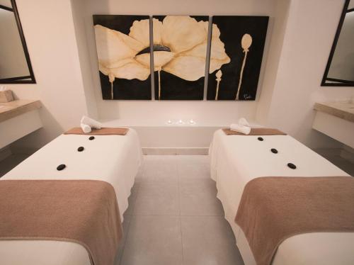 two beds in a room with a painting on the wall at Grand Decameron Los Cabos, A Trademark All-Inclusive Resort in San José del Cabo