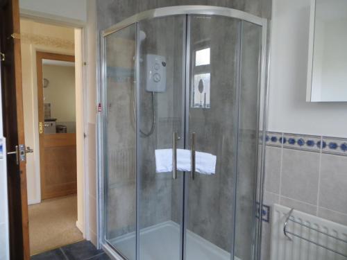 a shower with a glass door in a bathroom at Sunny Haven in Weymouth
