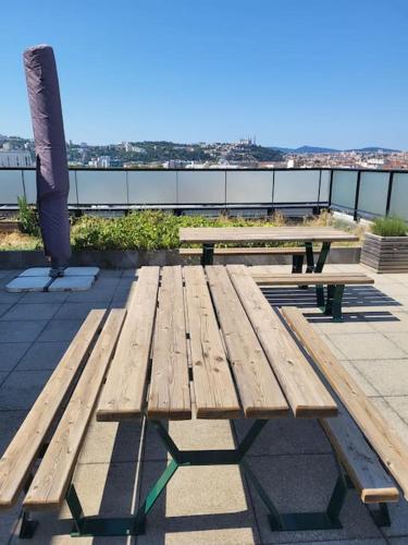 une table de pique-nique en bois posée au sommet d'un bâtiment dans l'établissement Appartement climatisé et moderne, à Lyon