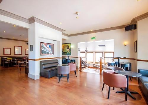a lobby with tables and chairs and a dining room at Staindrop Hotel in Sheffield