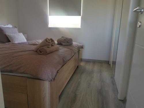 a bedroom with a bed with towels on it at Žuta kuća in Grude